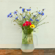 Still life. Glass decanter and wildflowers.